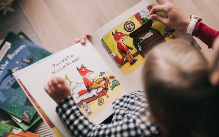 A child and adult reading an illustrated storybook together in a cozy setting.