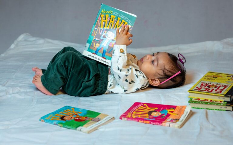 A cute baby lying on a bed, reading colorful children's books with enthusiasm. Captivating scene of early childhood lear