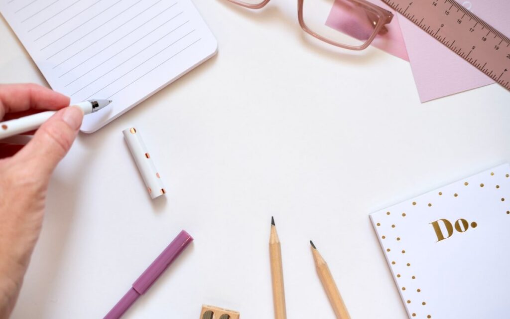 Aesthetic flat lay of pink and gold stationery essentials for creative workspaces.