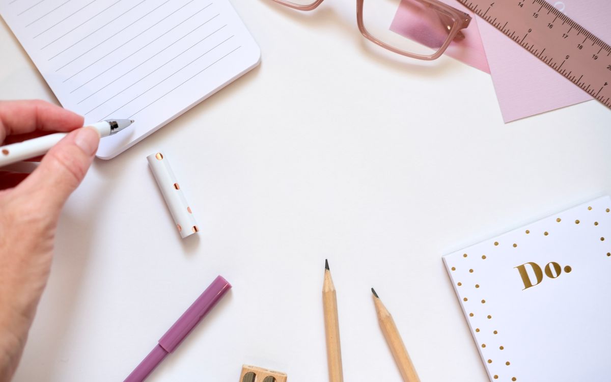 Aesthetic flat lay of pink and gold stationery essentials for creative workspaces.