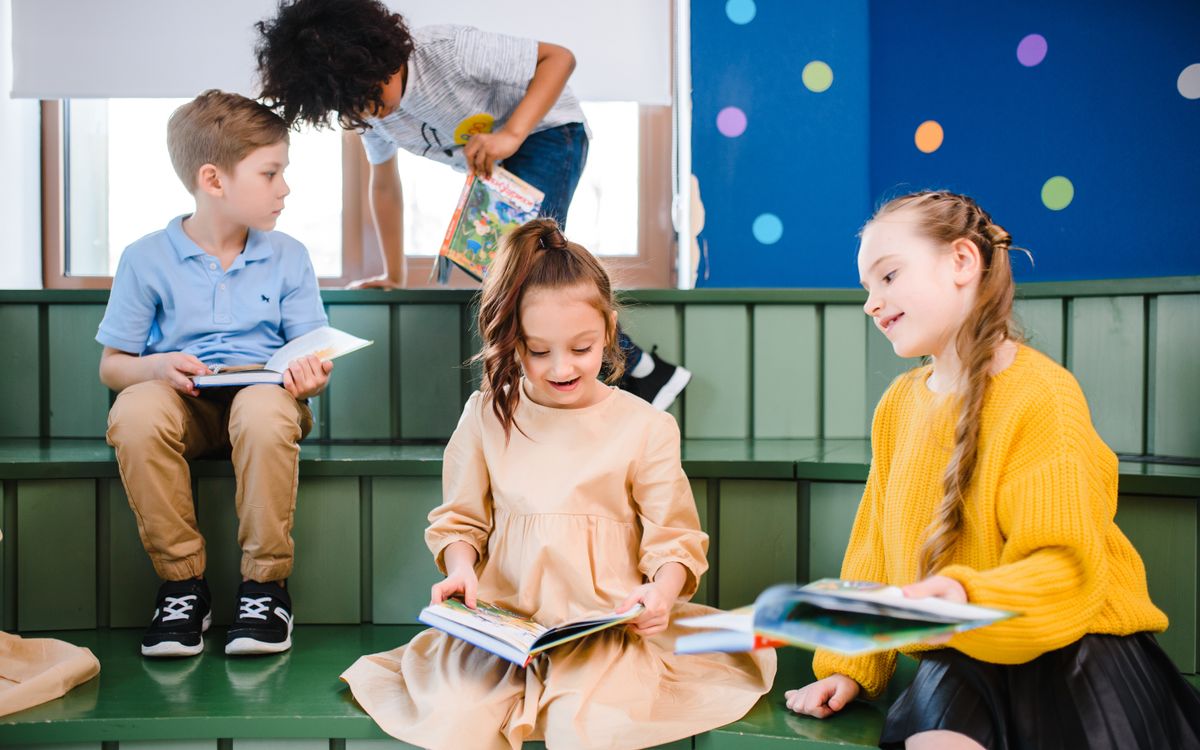 A group of children enjoying books in a vibrant indoor library setting.