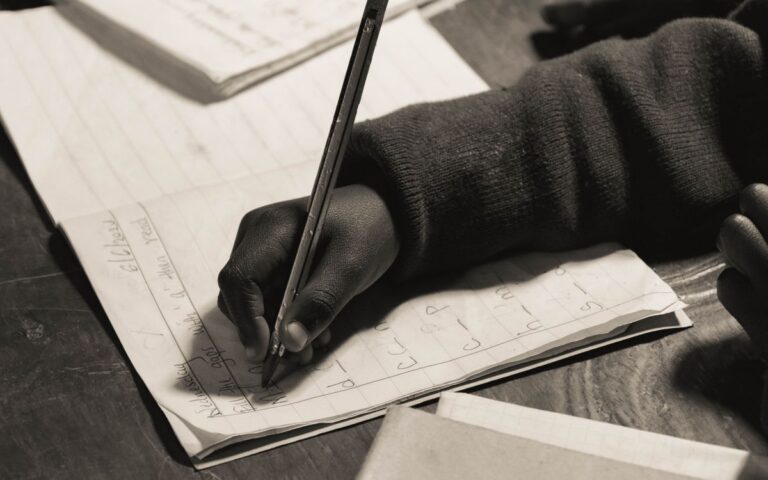 Close-up of a child writing in a notebook, focusing on handwriting practice.