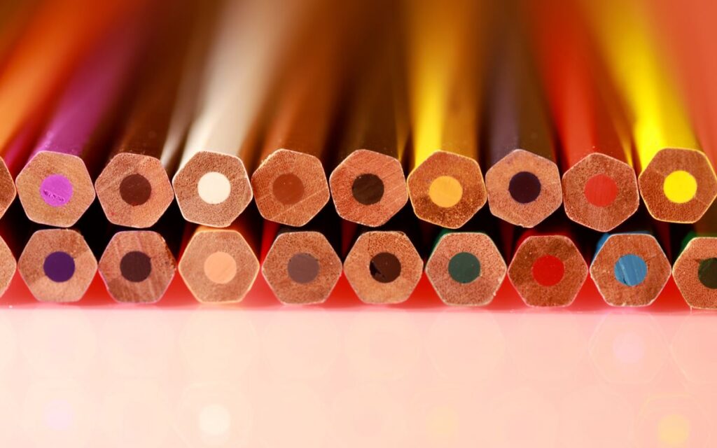 Bright multicolored hexagonal wooden pencils arranged neatly in rows. Ideal for education and art themes.