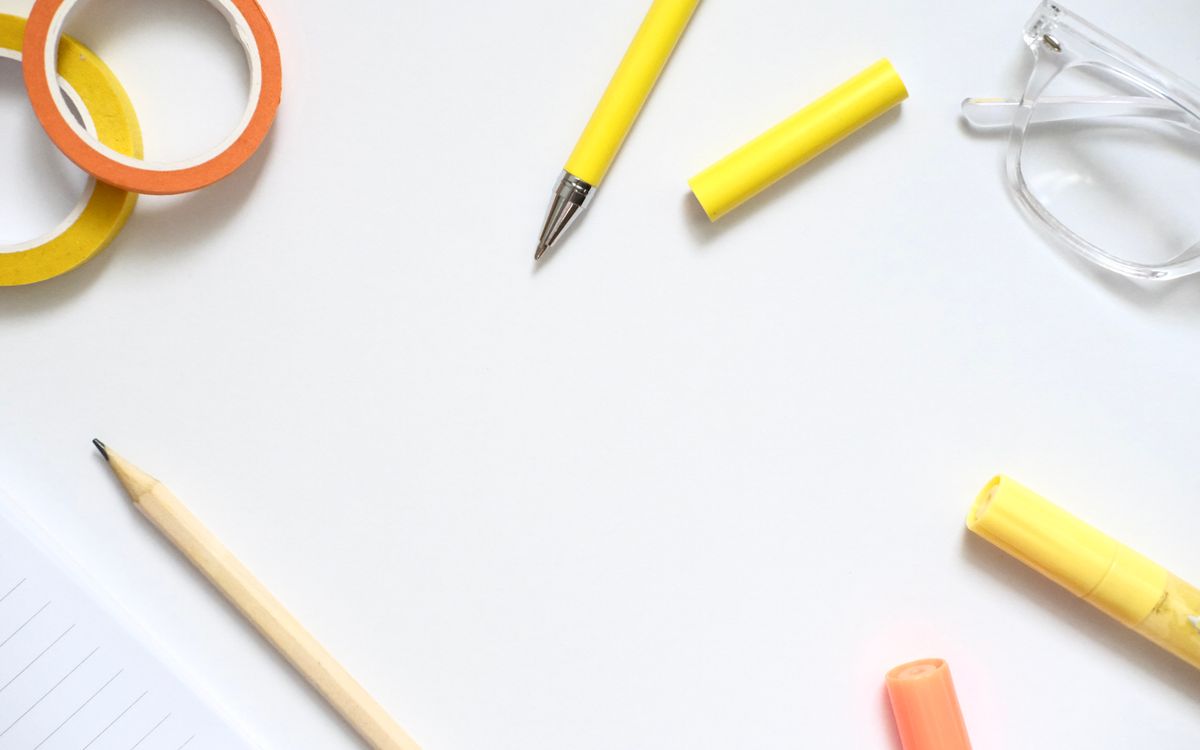 Flat lay of colorful office supplies on a white desk, perfect for creative workspace inspiration.