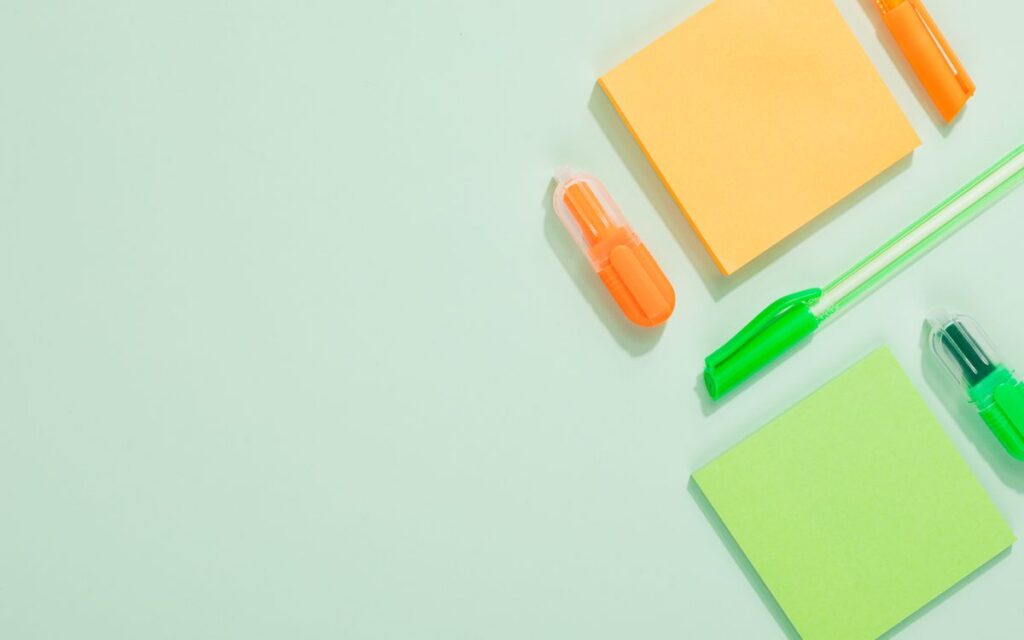 Bright stationery arranged creatively on a green background, perfect for school themes.