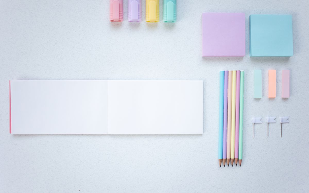 Flat lay of colorful stationery on a white background. Perfect for office and school supplies photography.
