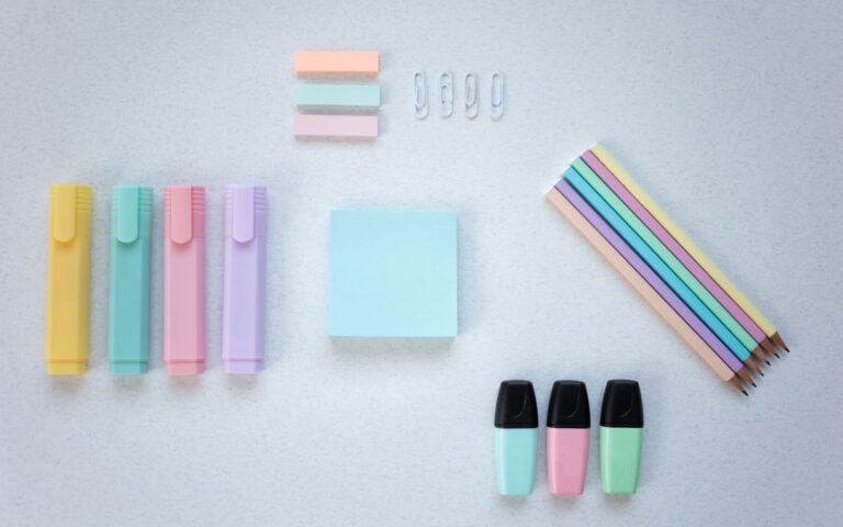 A vibrant collection of stationery items arranged flat on a white surface.