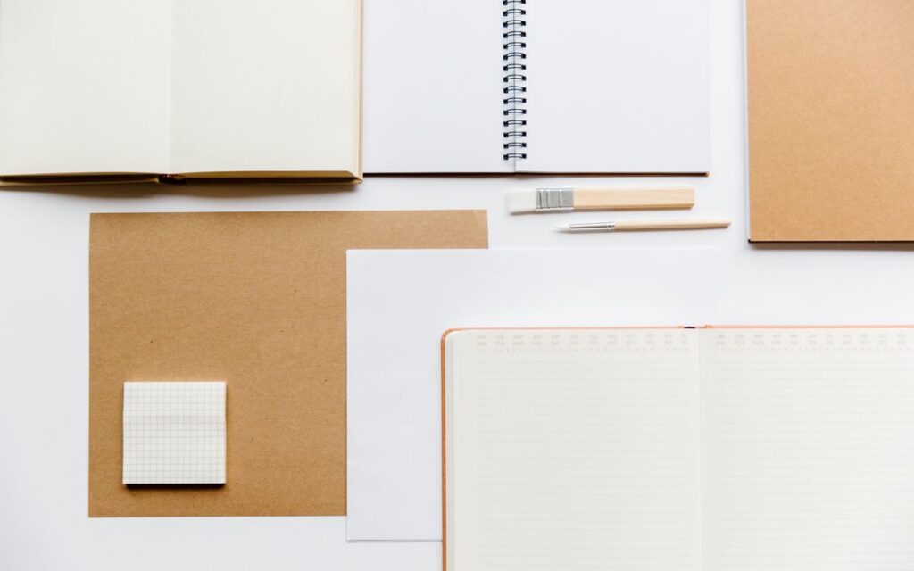 Flat lay of notebooks and stationery on a clean white background.