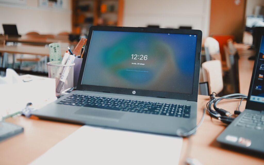 A classroom setting featuring laptops and desks, capturing a modern educational environment.