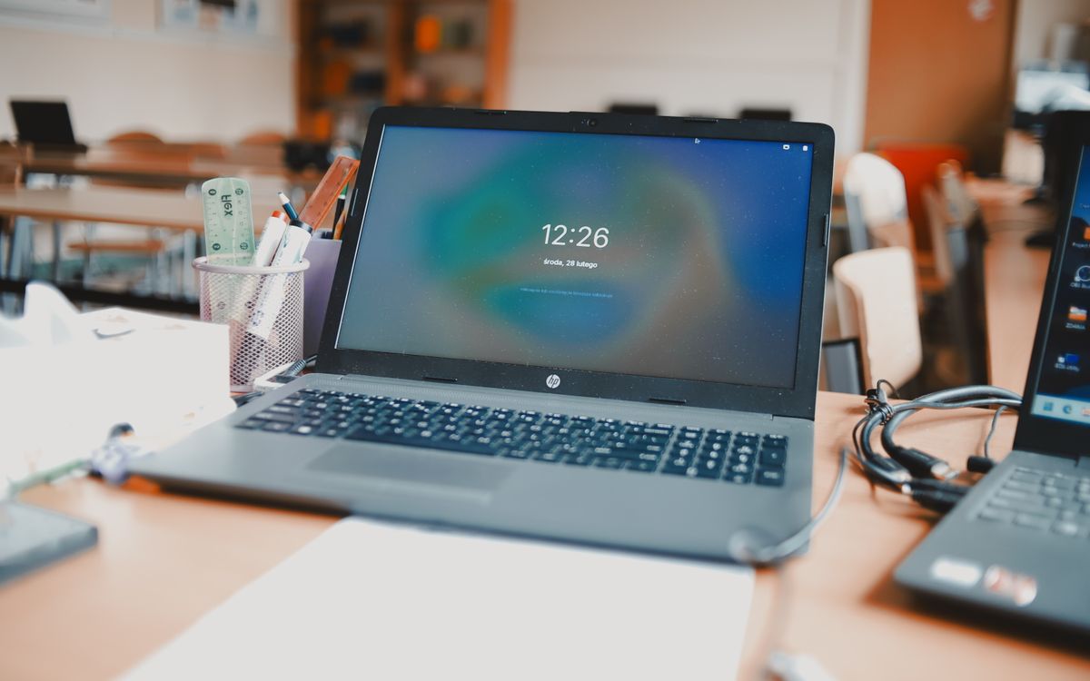 A classroom setting featuring laptops and desks, capturing a modern educational environment.