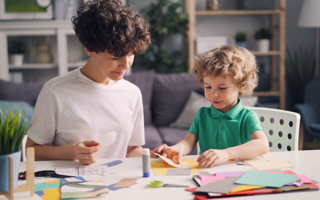 A mother and child enjoy a creative arts and crafts activity together at home.