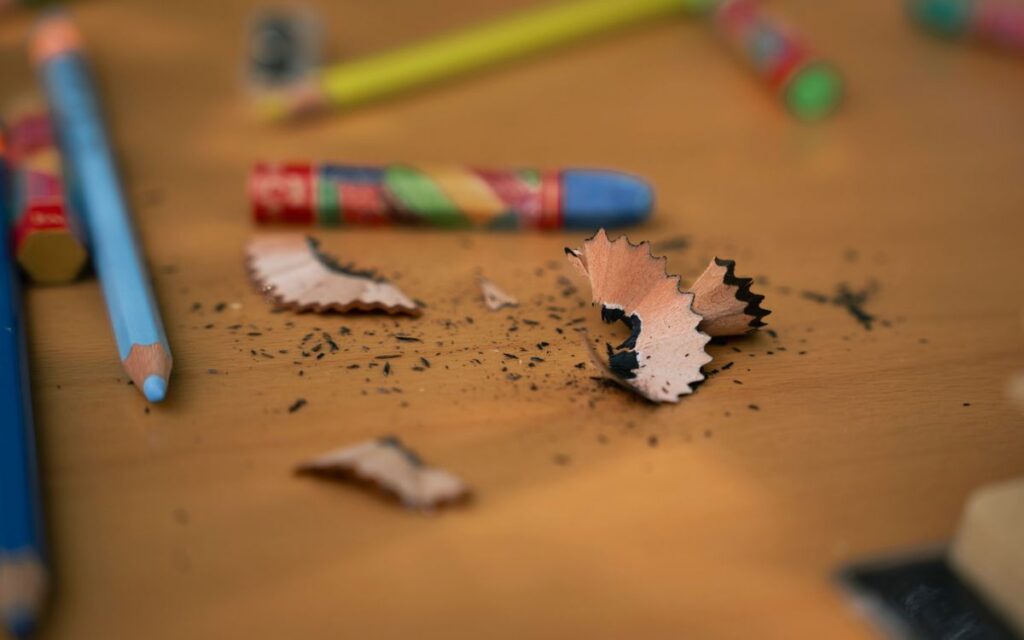 A creative scene with colorful pencils and shavings on a wooden desk, perfect for art themes.