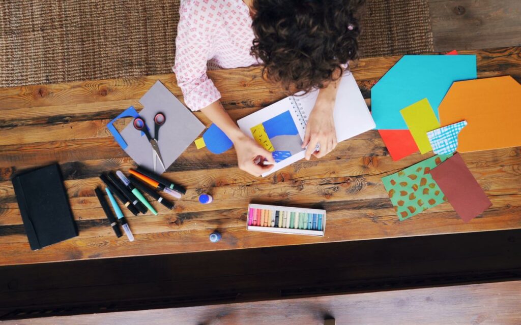 Crafting station view from above showing art supplies and creative process.