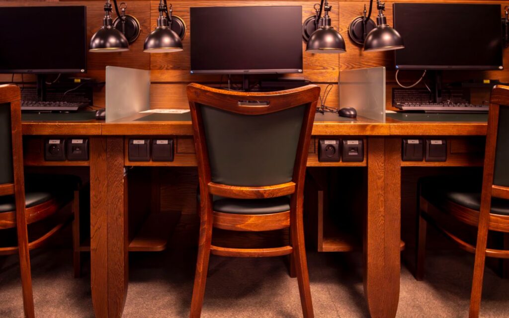 Library computer workstations in Wrocław with classic wooden design and modern computers.